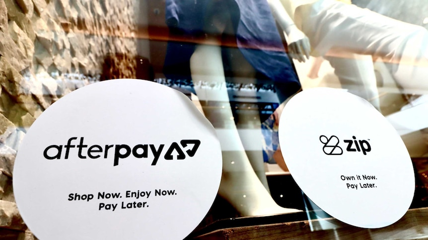 Stickers advertising Afterpay and Zip on the window of a clothing store.