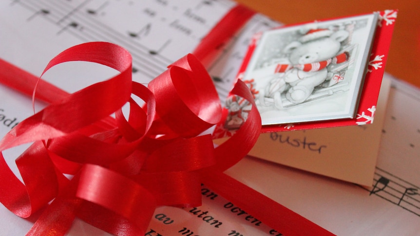 A Christmas present with a bow sits on a table.