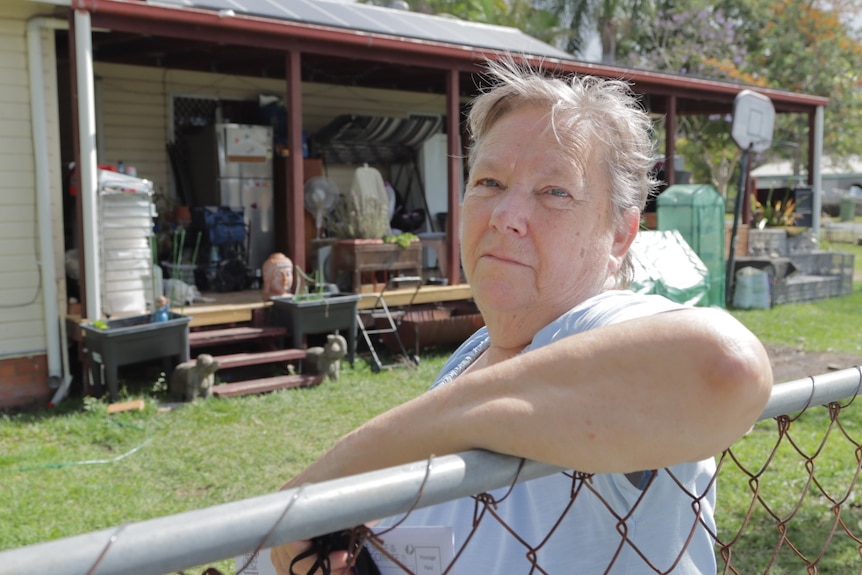 Cheryl Love is pictured at her fence, outside her home. 