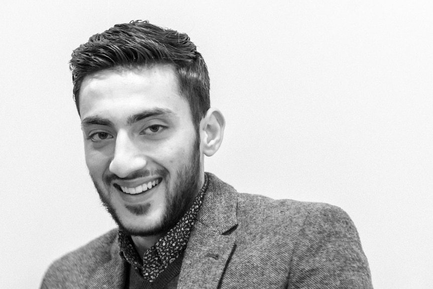 A black and white image of a man smiling.