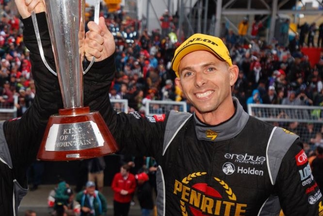 Supercars driver Luke Youlden smiles as he holds up a trophy