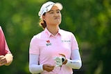 Australian golfer Minjee Lee looks satisfied as she takes off her glove after hitting an approach to the final green.