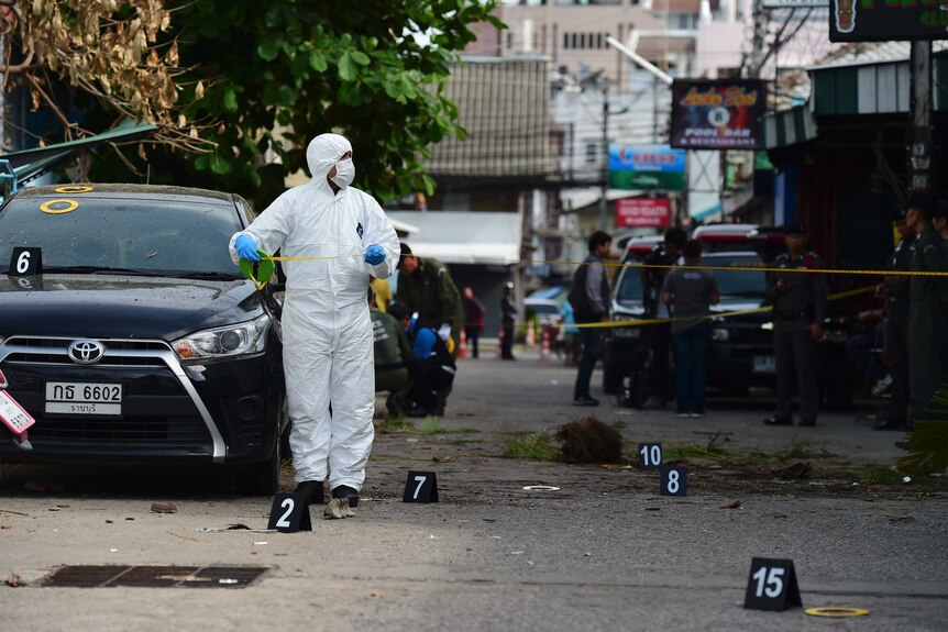 An investigation official collects evidence after a bomb exploded in Hua Hin