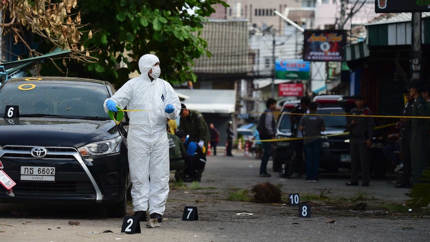 An investigation official collects evidence from the crime scene in Hua Hin.