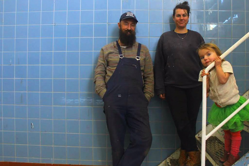 Chris, Gabbie and Hazel Moore stand in the old Orbost Butter Factory, which the couple are converting into a brewery.