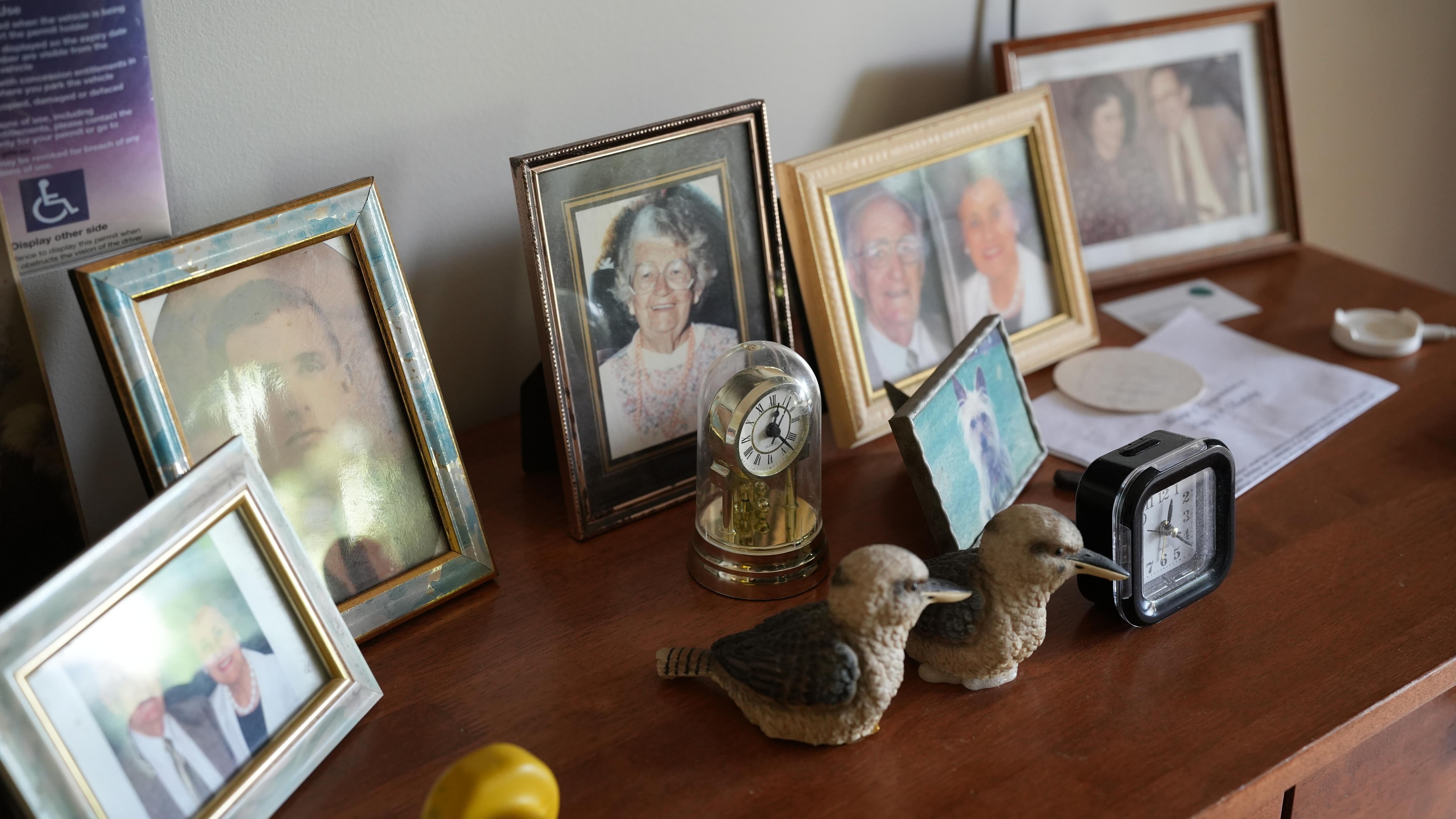 A bureau set up with photos and trinkets.