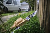 Flowers and police tape in scene of crime
