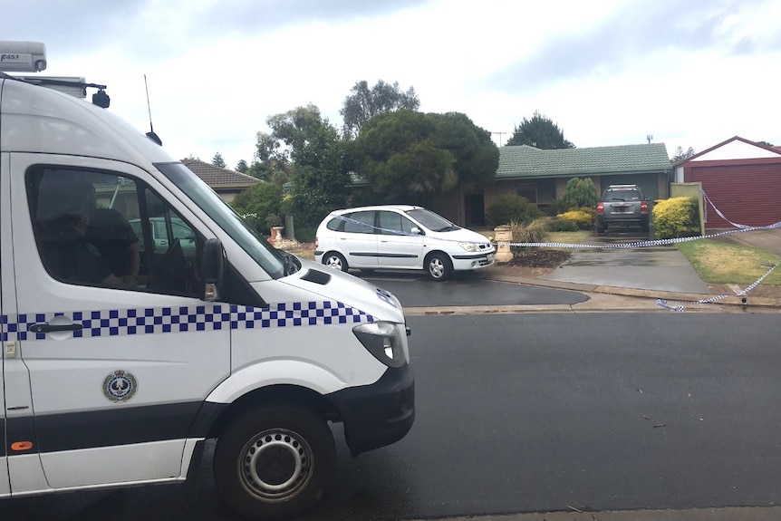 Police van outside a house which is cordoned off with crime scene tape.