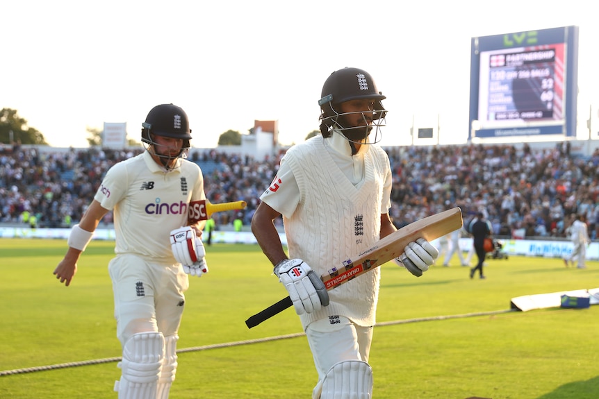 Two England Test cricket openers leave the ground to walk to the pavilion after the end of the day's play. 