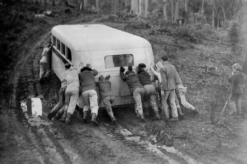 Members of the Launceston Walking Club push their bus out of mud in the 1950s.