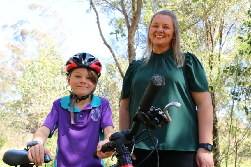 A boy and a woman smile at the camera