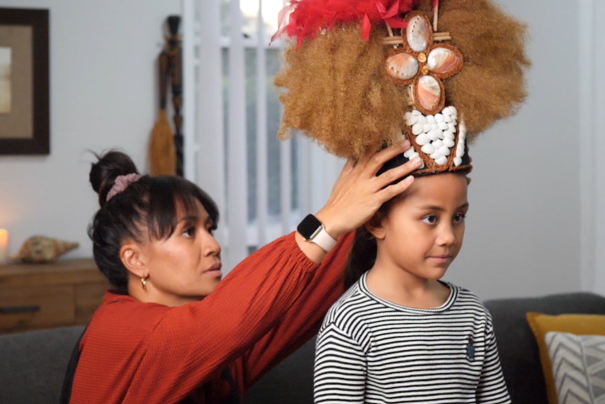 Mum puts colourful fluffy head dress on daughter