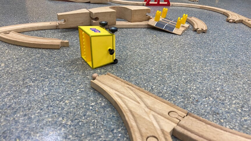 Wooden railway tracks and a fallen yellow carriage