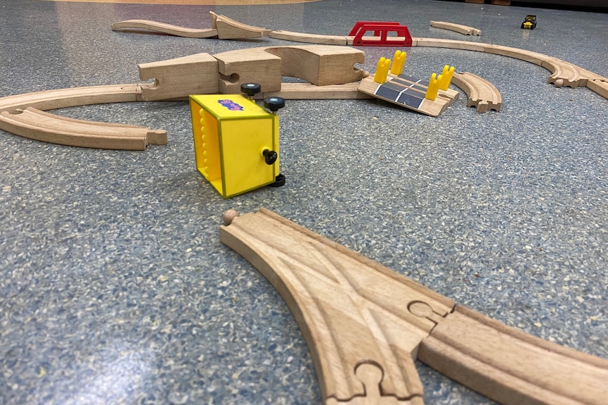 Wooden railway tracks and a fallen yellow carriage