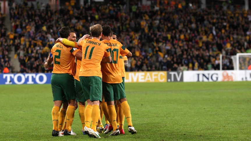 Late escape ... the Socceroos celebrate Luke Wilkshire's 68th-minute equaliser.