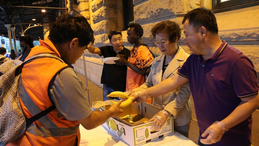 Charity workers hand out food to homeless people at Central Station in February.