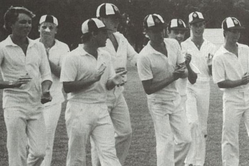 A group of young cricketers leave the field.