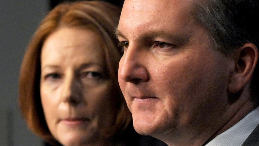 Julia Gillard listens to Chris Bowen during a press conference in Canberra. (AAP: Alan Porritt)