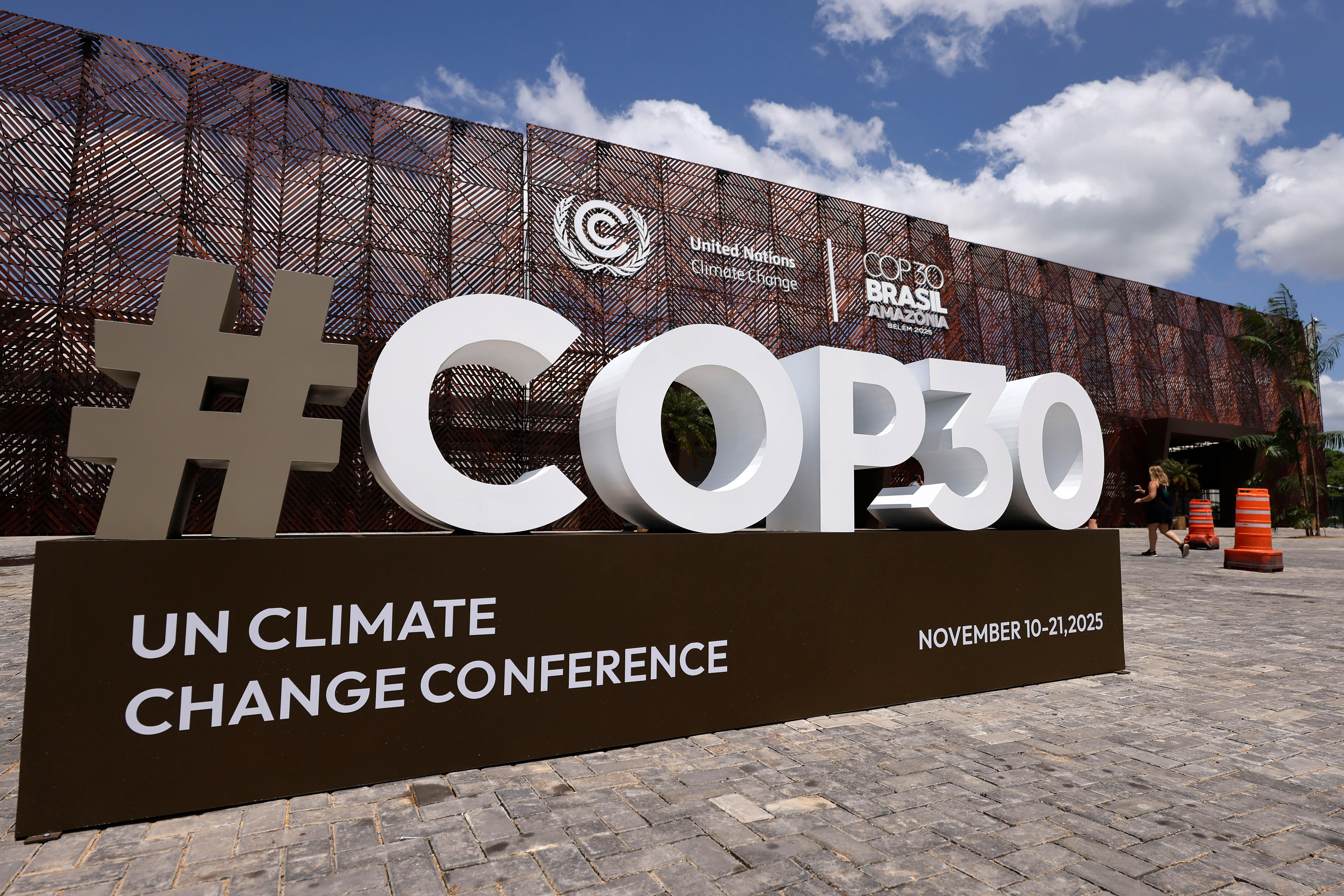 A large white sign on a pavement reads #COP30