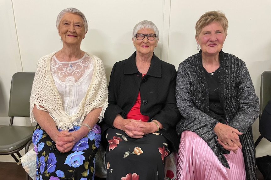 Photo of three women sitting next to each other.