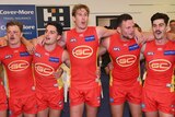 Gold Coast Suns including Tom Lynch (3L) and Steven May (4L) sing the song after beating Carlton.
