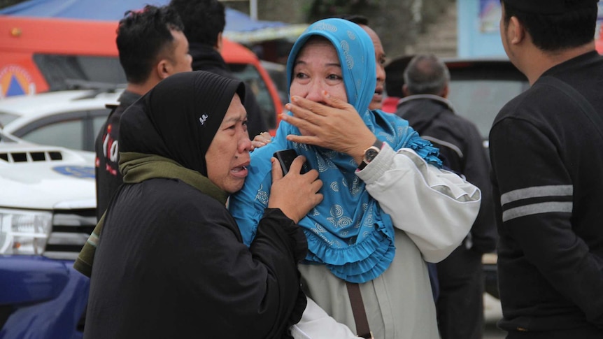 Relatives weep at Tigaras port after learning that their family members are among the missing.