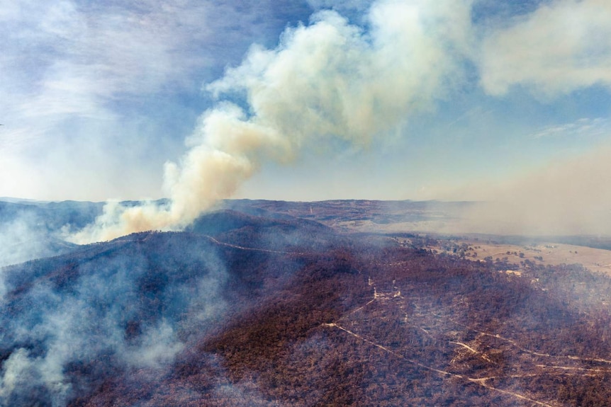 aerial view of a bushfire burning over bushland