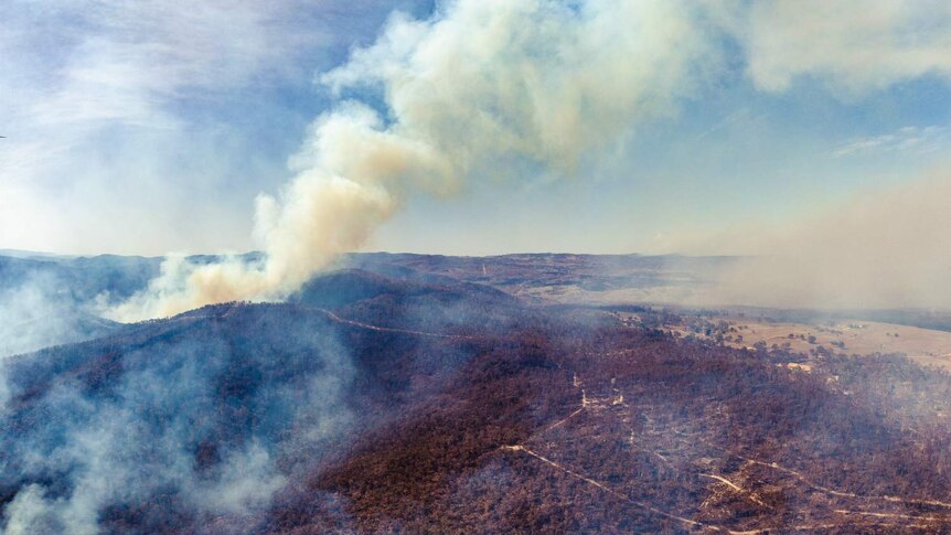 aerial view of a bushfire burning over bushland