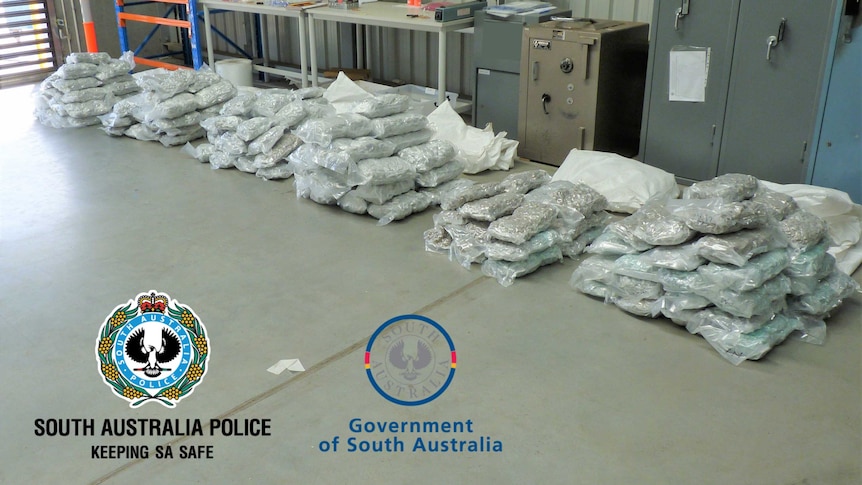 Wrapped drugs lying on the floor of a shed, in a photo released by SA Police and the AFP