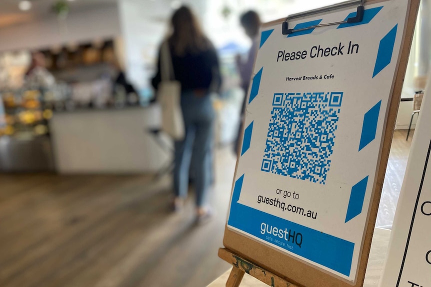 A QR code on a stand, on a table outside a cafe.