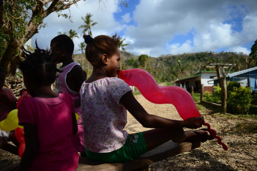 Children play with balloons in the village of Saama, Vanuatu