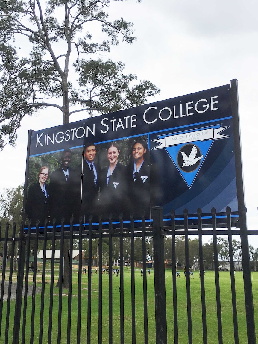 Sign of Kingston State College behind a fence.