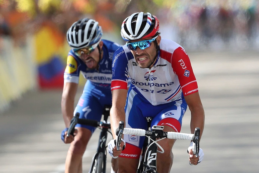 Thibaut Pinot and Julian Alaphilippe grimace as they ride their bikes