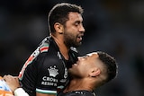 South Sydney Rabbitohs' Alex Johnston is lifted into the air by a teammate after a try. A Tigers player is nearby.