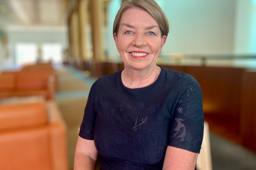 A woman smiles at the camera.