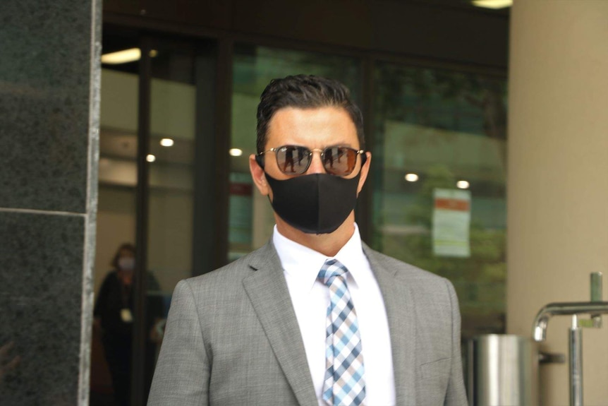Owner of Bada Bing cafe Nathan Sharp leaves court wearing a facemask and a suit.