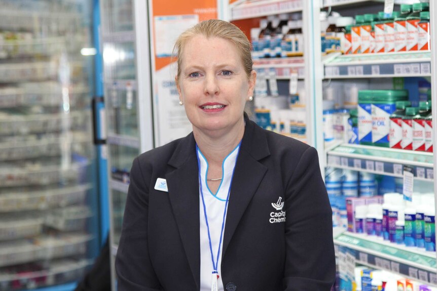 Honor Penprase smiles while standing in her pharmacy.