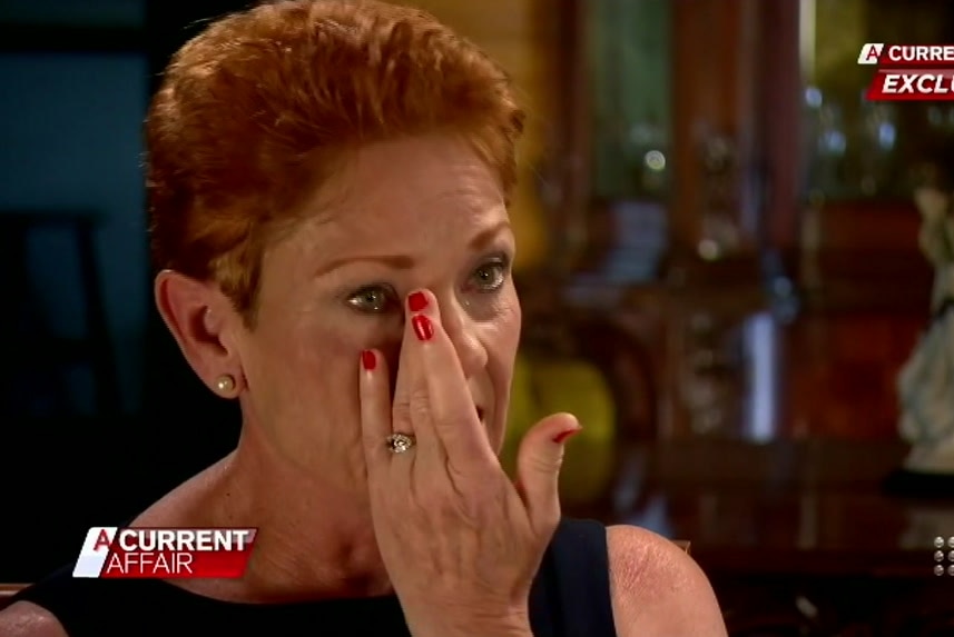 Pauline Hanson wipes away tears during an interview on A Current Affair, the branding of which is super-imposed on the screen.