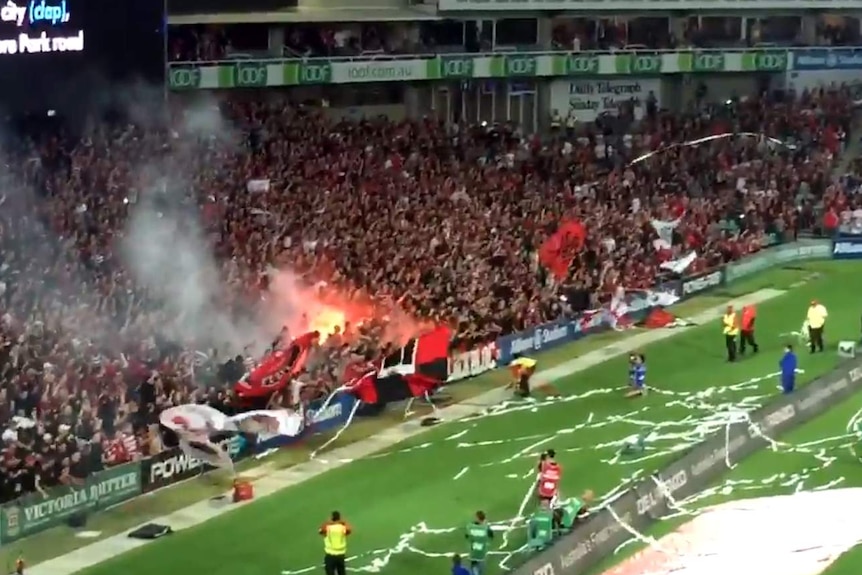 Spectators at a Sydney soccer match light flares