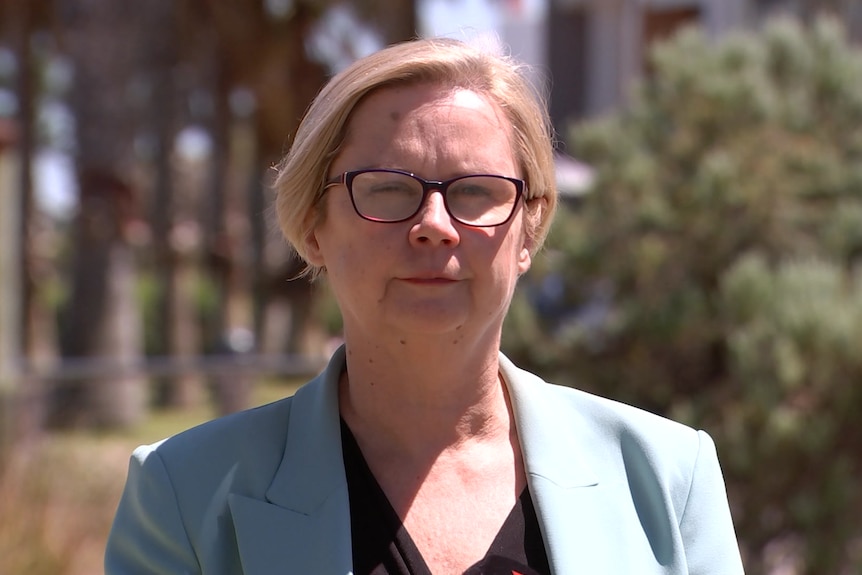 Clare Scriven looks directly at the camera during a press conference in an outdoor location