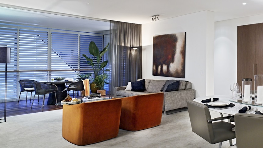 An interior image of an apartment at the Queens Riverside development, showing furniture, art and plants.