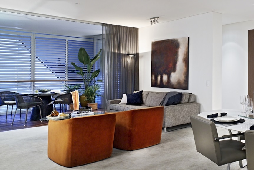 An interior image of an apartment at the Queens Riverside development, showing furniture, art and plants.