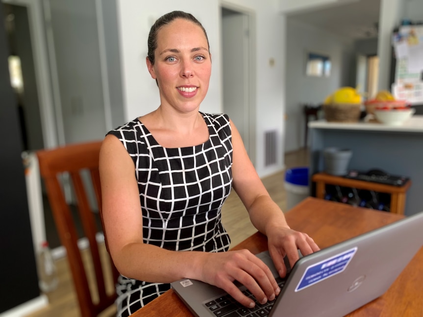 ANZ senior economist Catherine Birch types on her laptop at her dining table.