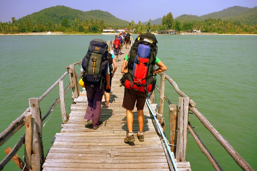 Backpackers walking over a bridge