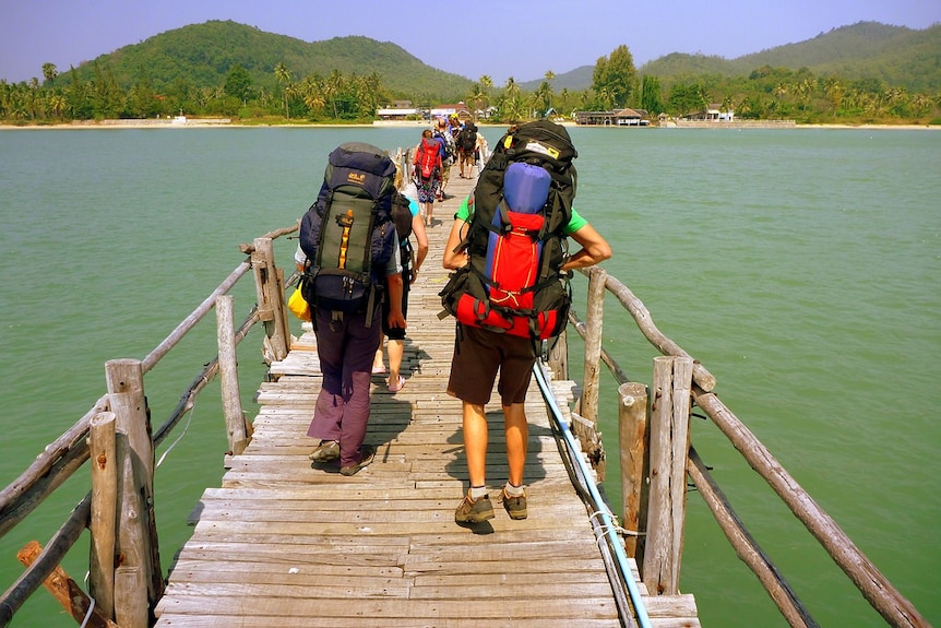 Backpackers walking over a bridge