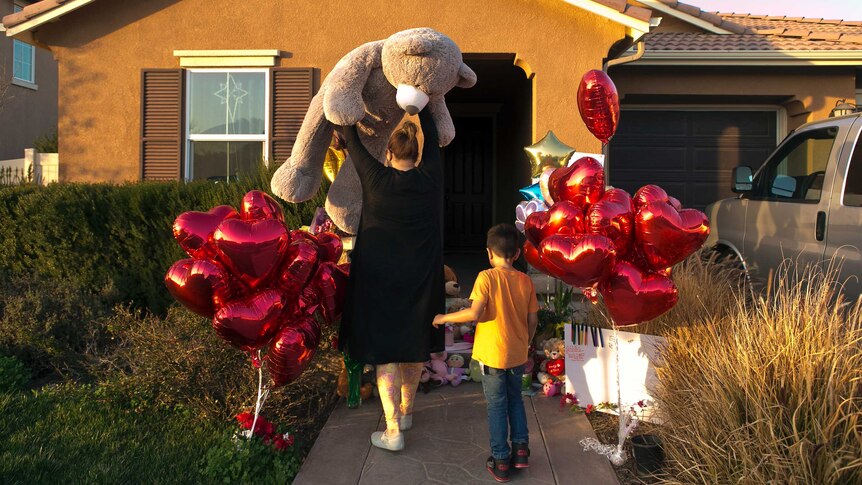 A neighbour and her 6-year-old son bring a large "Teddy" as a gift for the 13 children