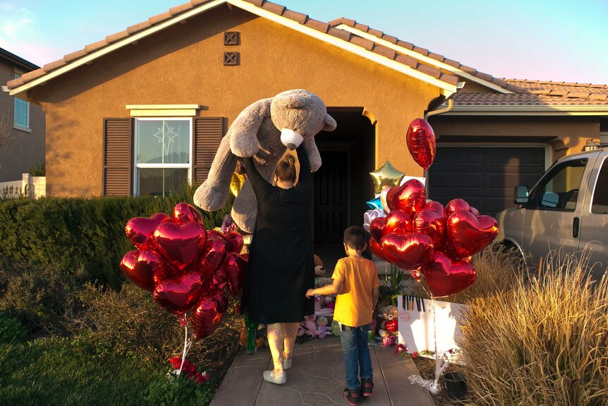 A neighbour and her 6-year-old son bring a large "Teddy" as a gift for the 13 children