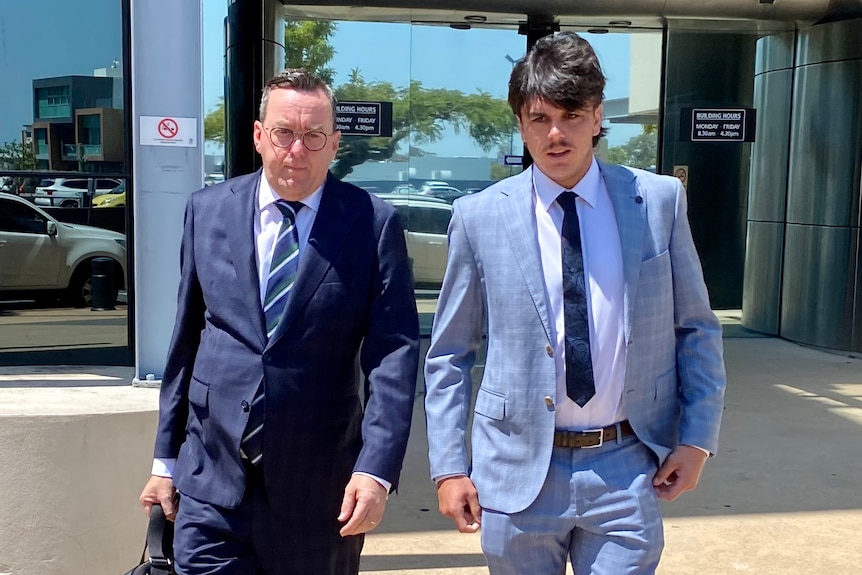 AFL Elijah Hollands walks from a courthouse with his lawyer