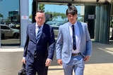 AFL Elijah Hollands walks from a courthouse with his lawyer