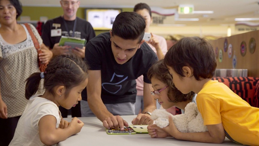 Taj Pabari showing children how to build their own tablet.